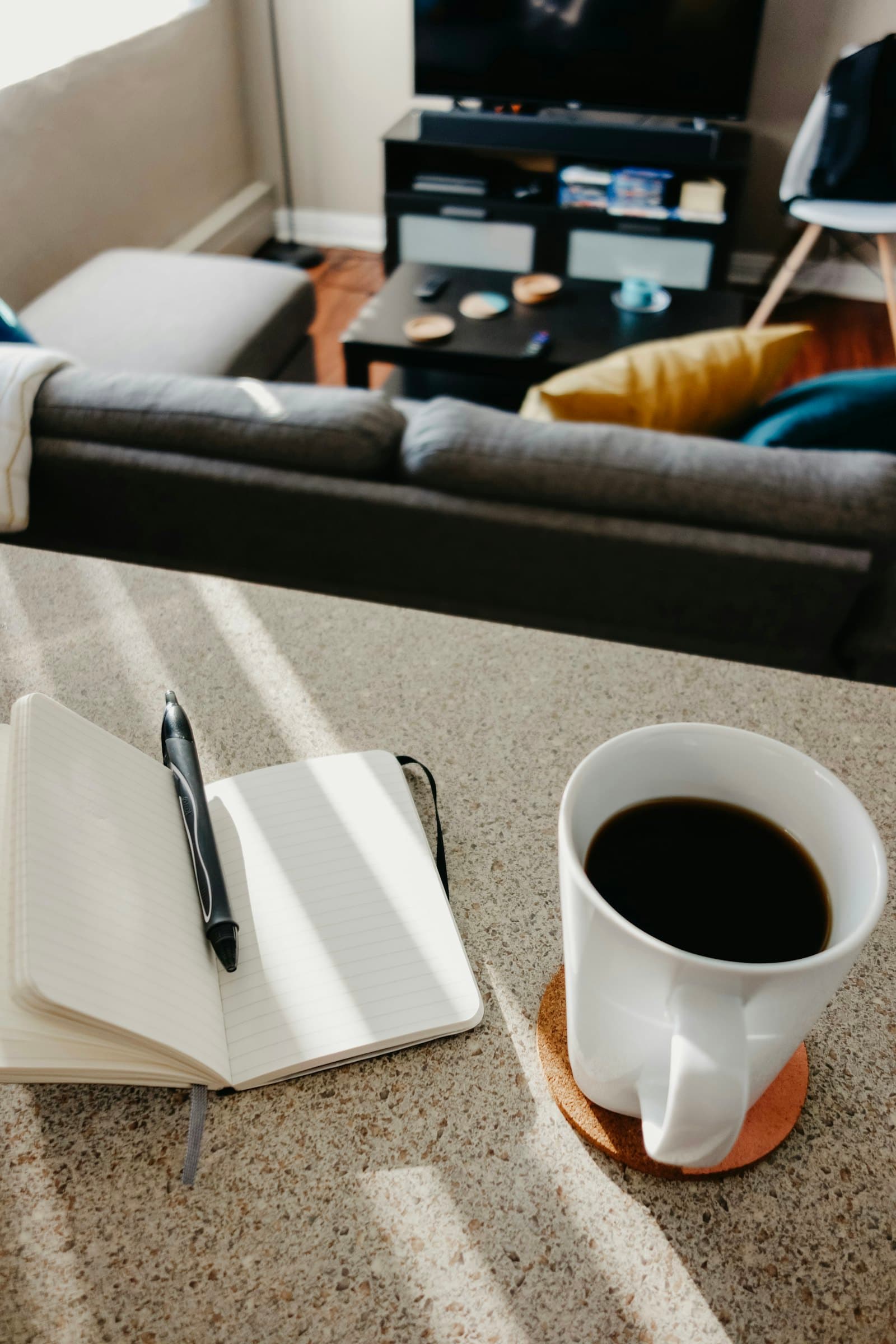 An open notebook and a cup of coffee in morning light