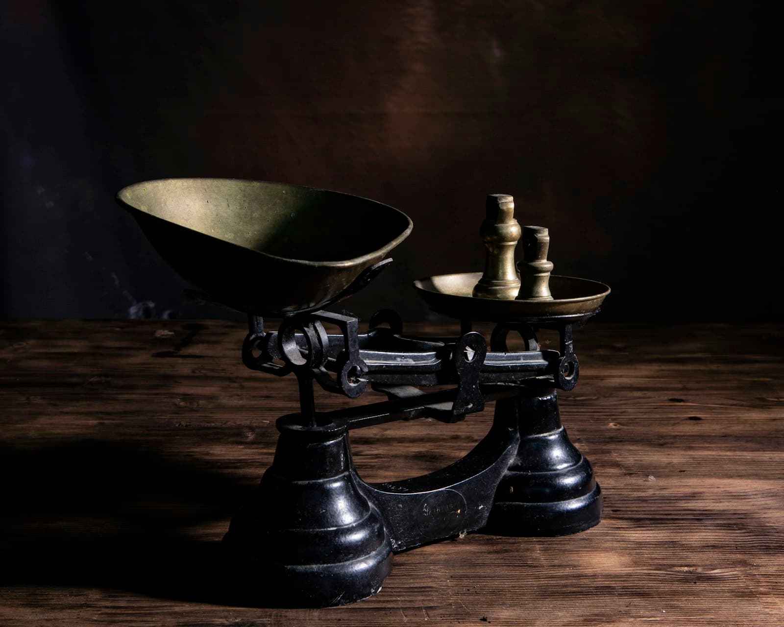 An old kitchen balance with brass weights on a wooden table