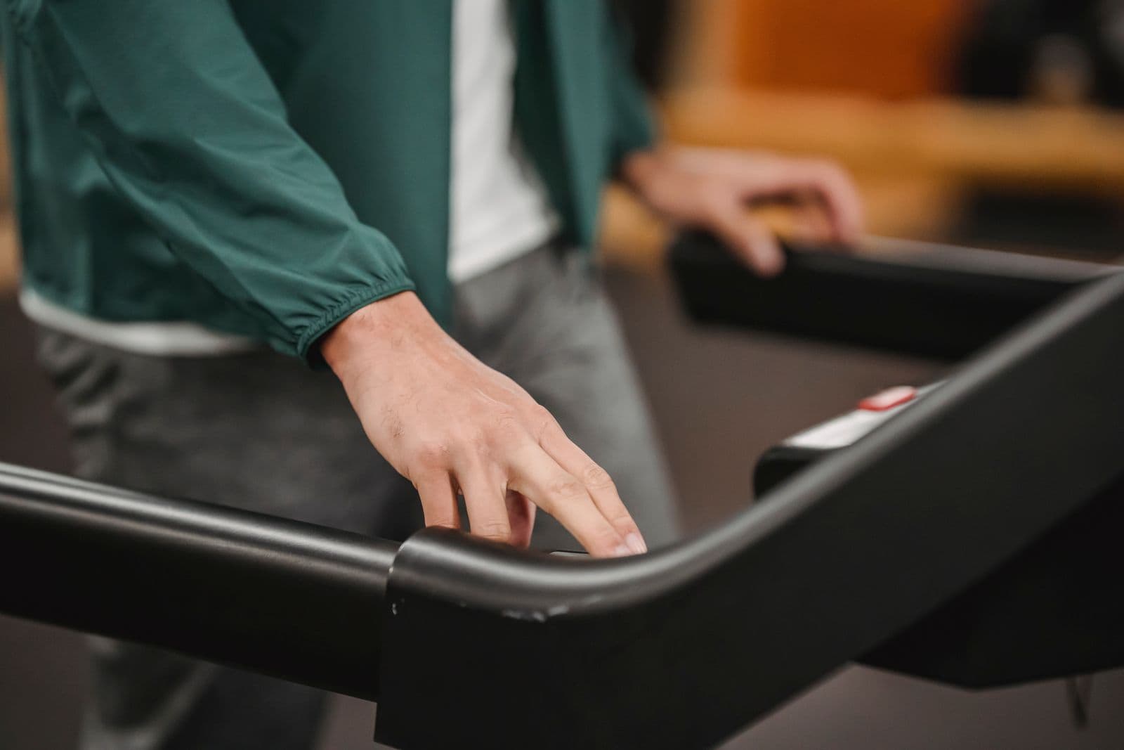 A hand resting on a treadmill's rail, mid-session