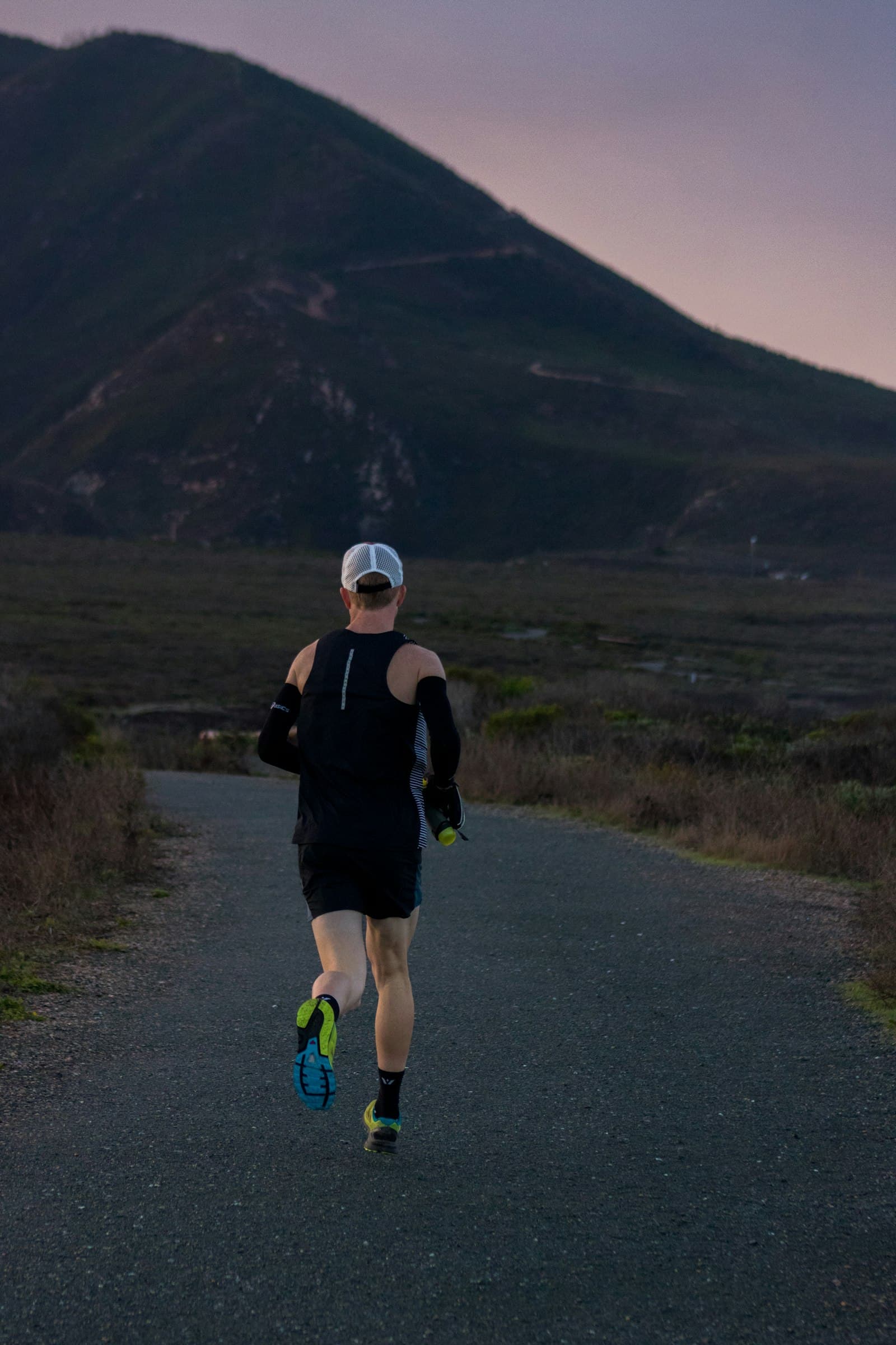 A runner on a quiet mountain road at first light