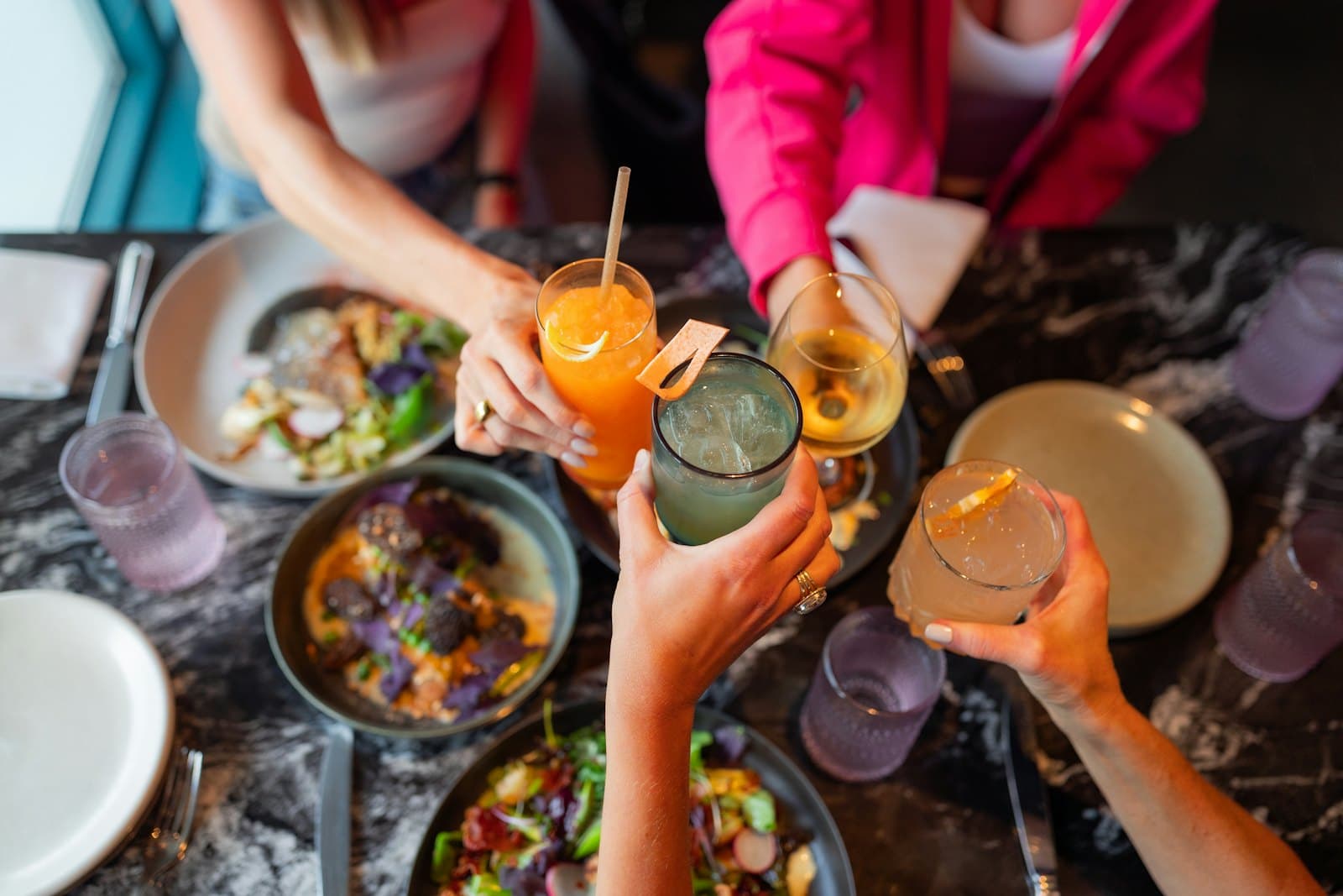 Friends raising their glasses over a table of shared food